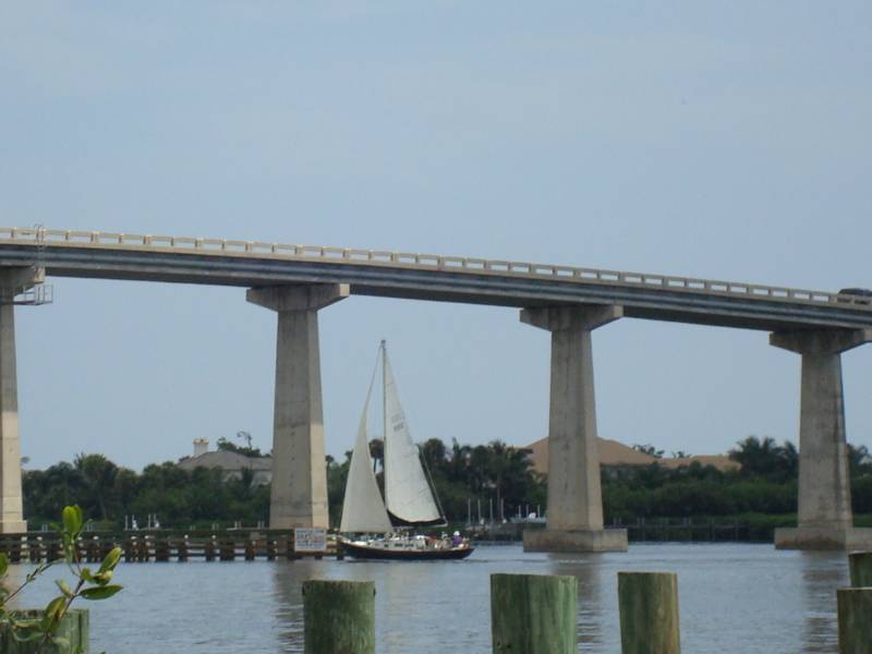 A Sailboat Going Under a Bridge